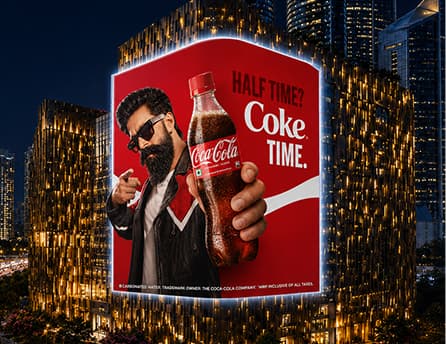 Coca-Cola creative running on BIG ONE's curved display above a city street at night